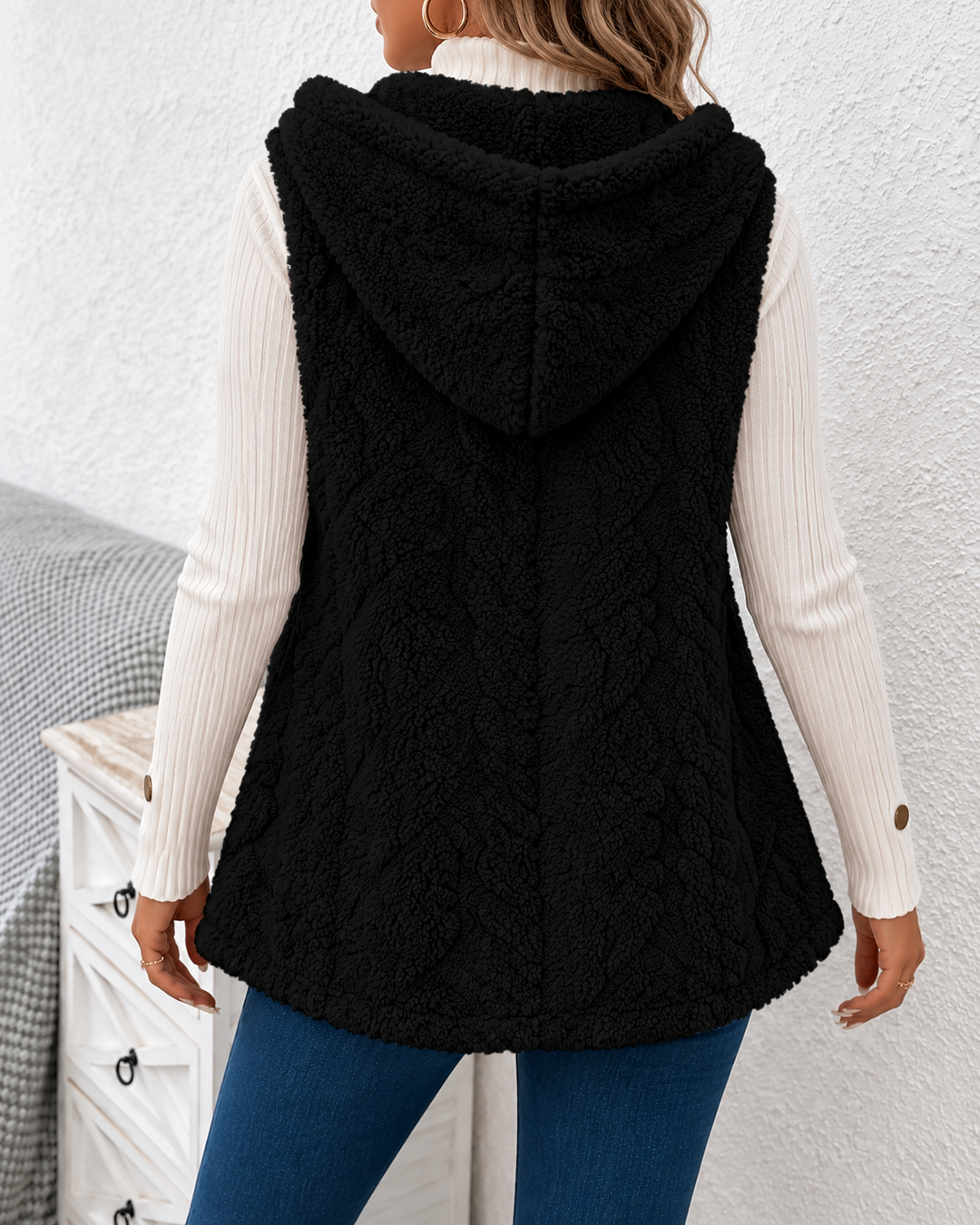 Sleeveless women's knitted vest with a cable-knit pattern and pockets