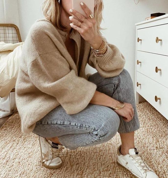 Willemijn vest gecombineerd met jeans en sneakers, zittende pose